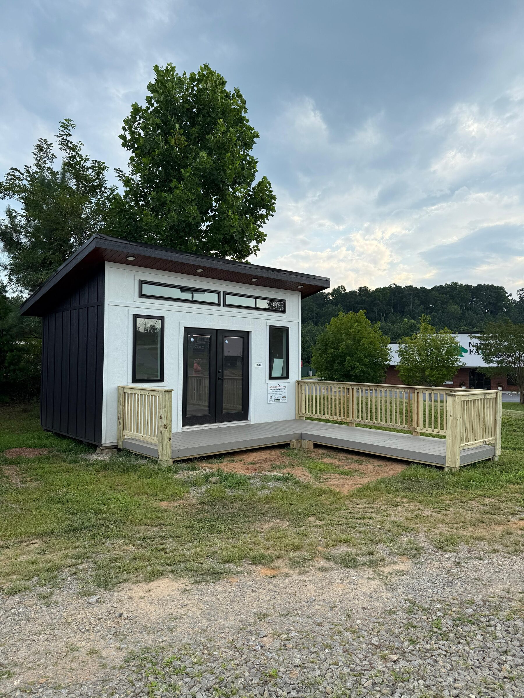 Backyard studio accessory building with a platform deck and railing