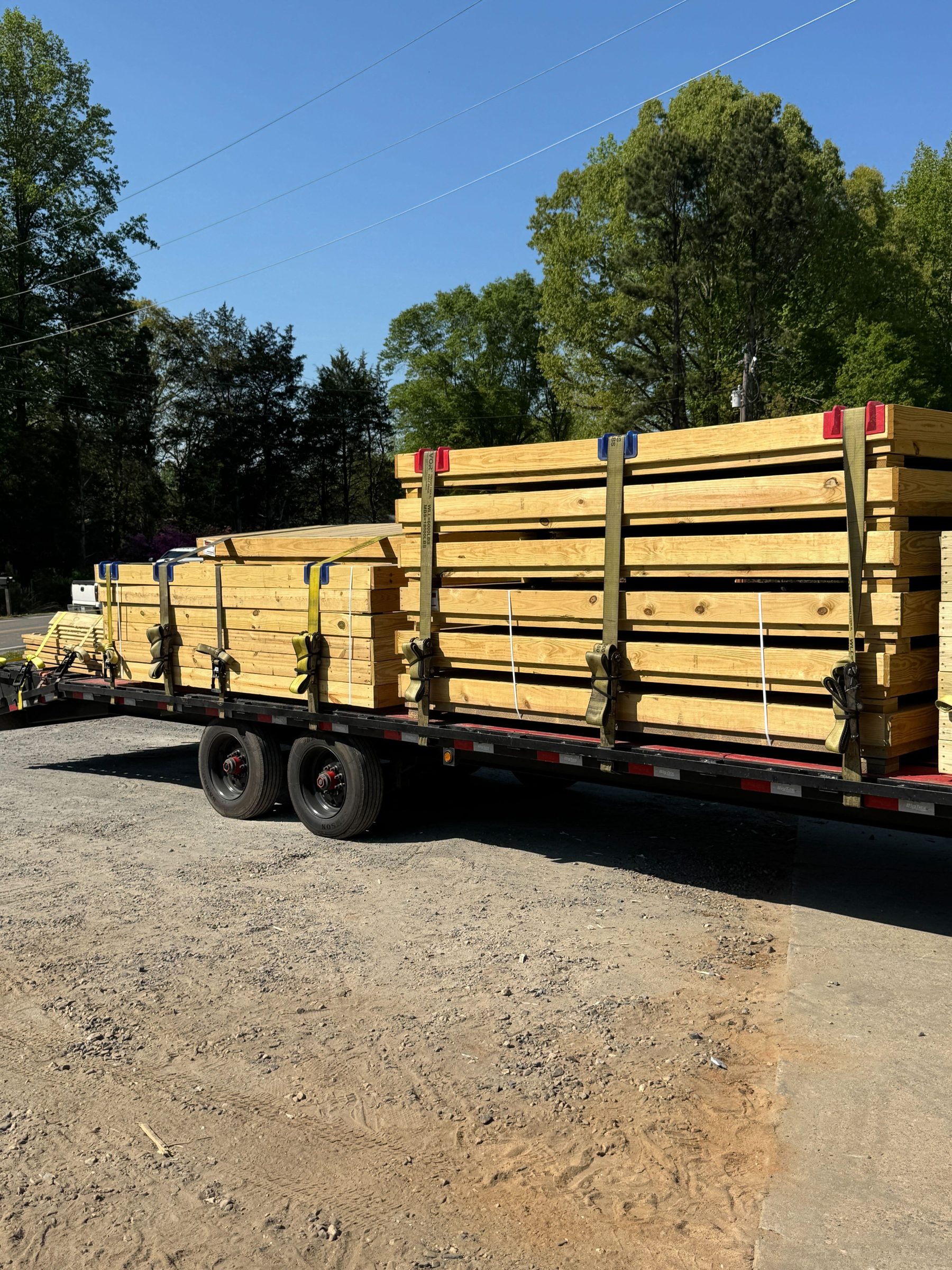 Pre-cut platform components stacked and strapped on a flatbed trailer for delivery