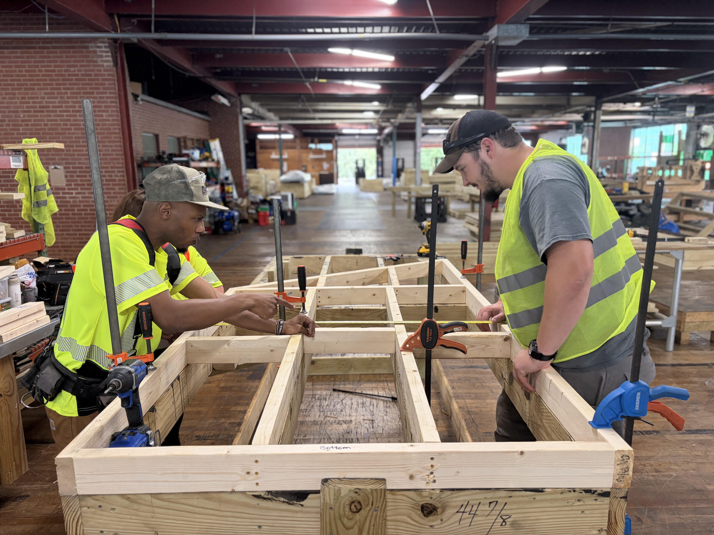 FlatSpot crew measuring a FlatForm platform frame during fabrication